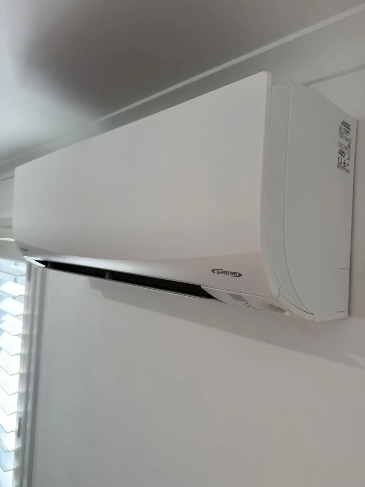 Wall-mounted inverter split system air conditioner installed in a home